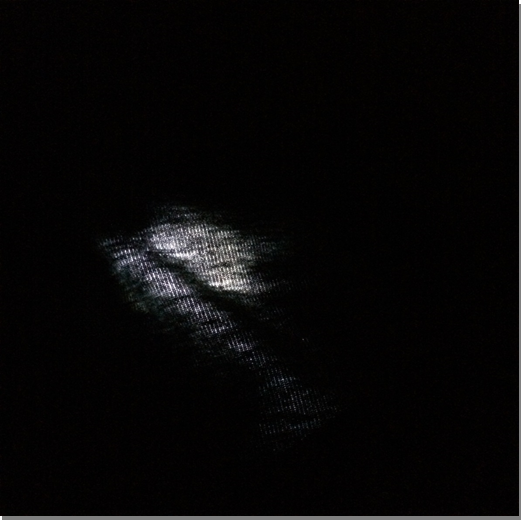 A close-up of cloth lit from underneath in an otherwise dark space