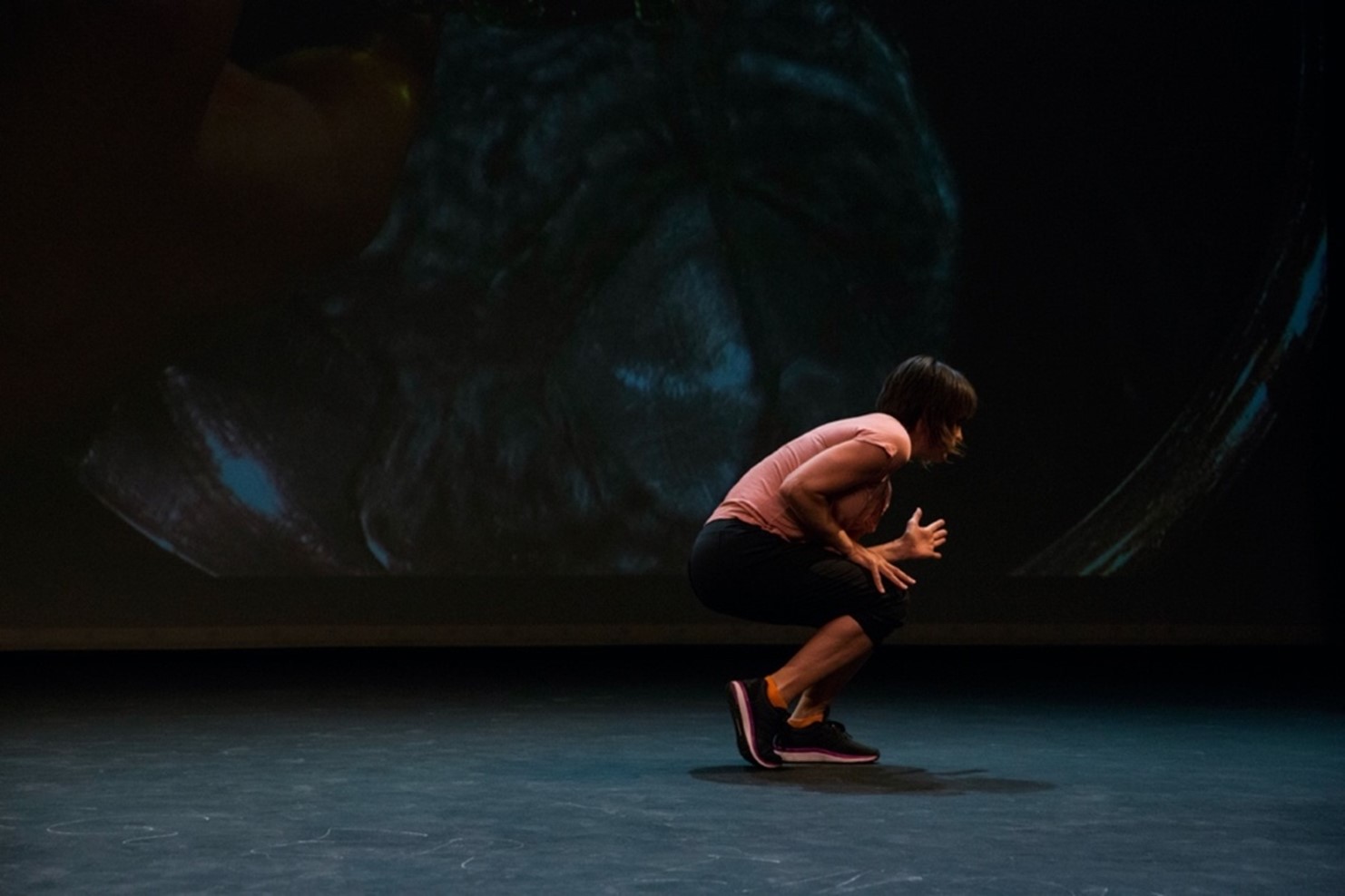 Photo of a crouching woman on a stage. Photo; Camilla Jensen