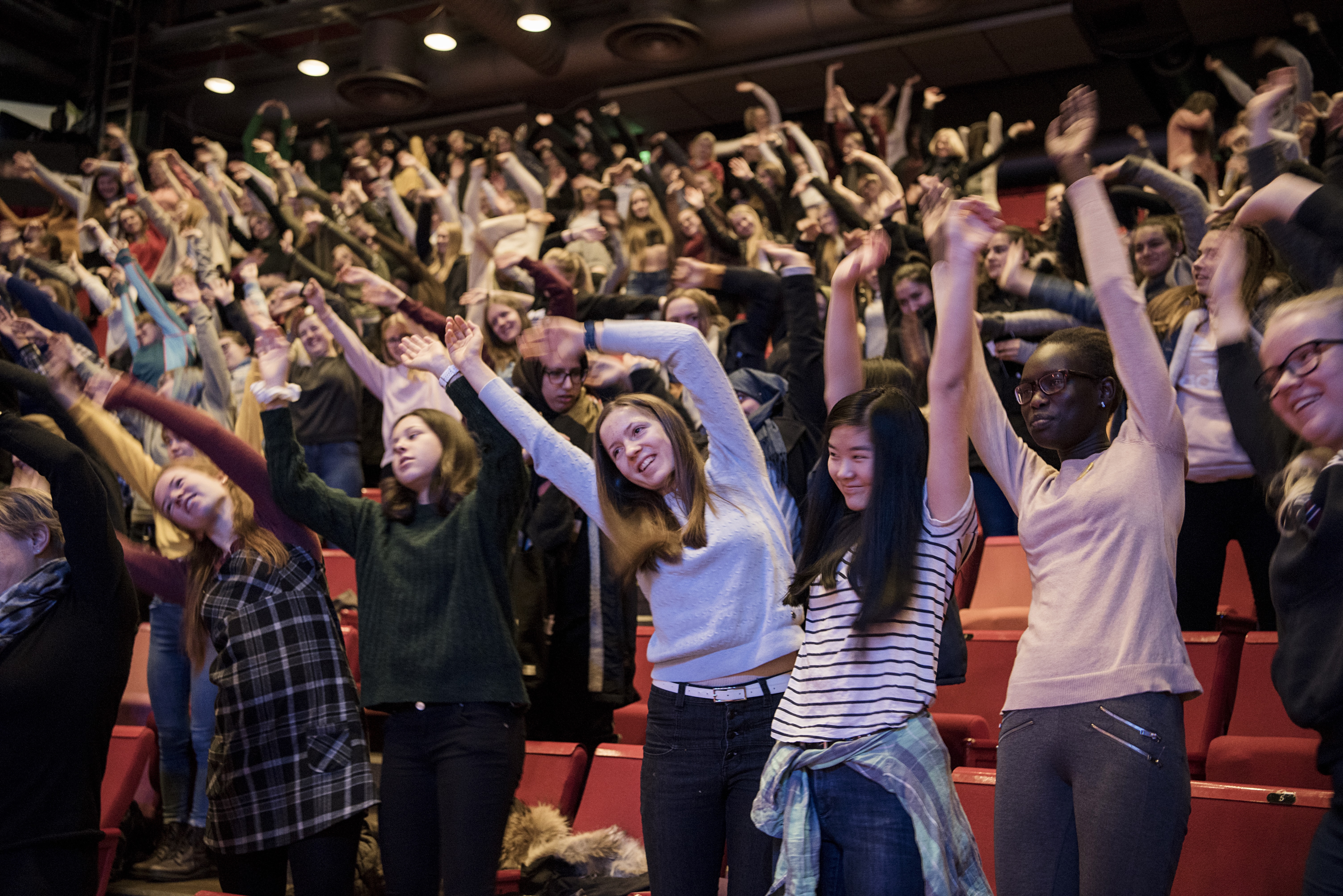 Students waving their hands in an auditorium