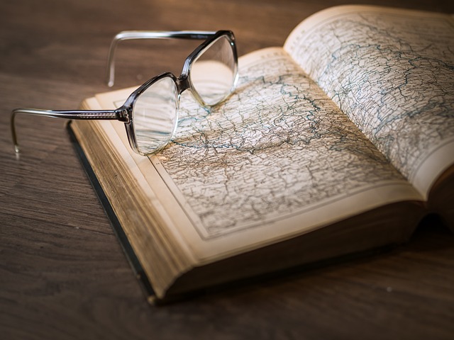 A book with maps and a pair of eye glasses
