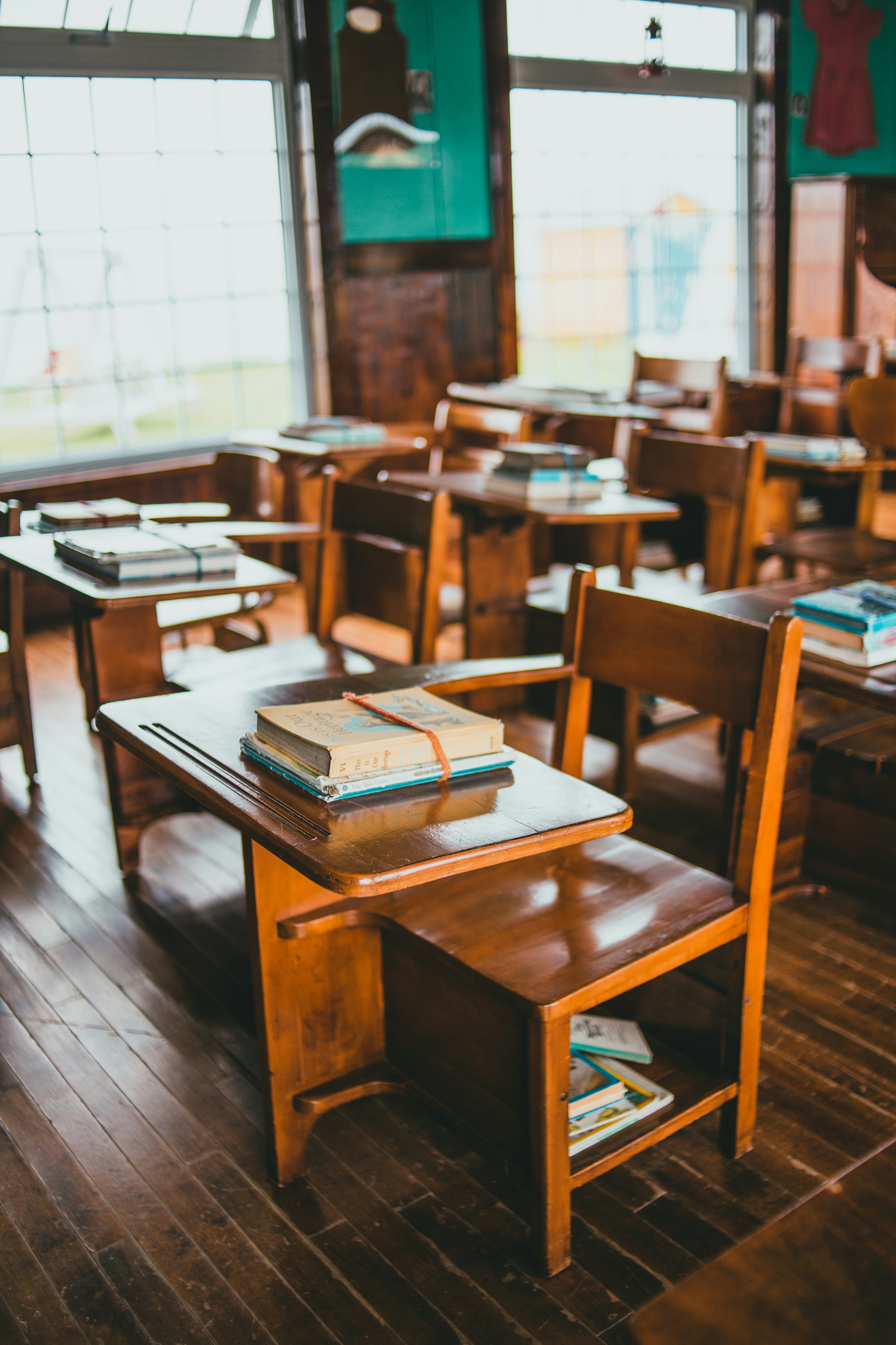 A classroom with desks, chairs, and books. Photo by Erik Mclean on Unsplash