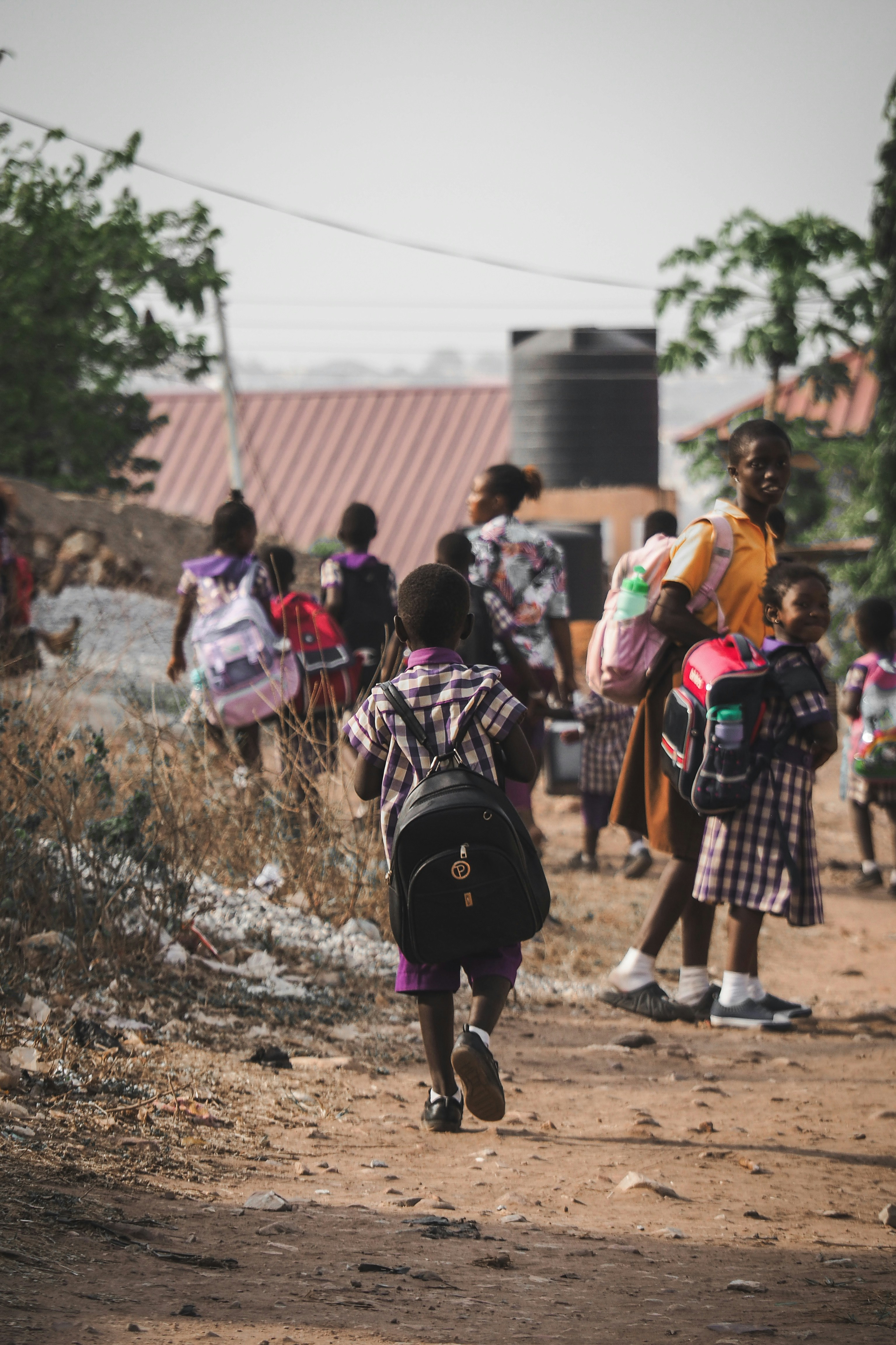 School children walking on dirt road to school