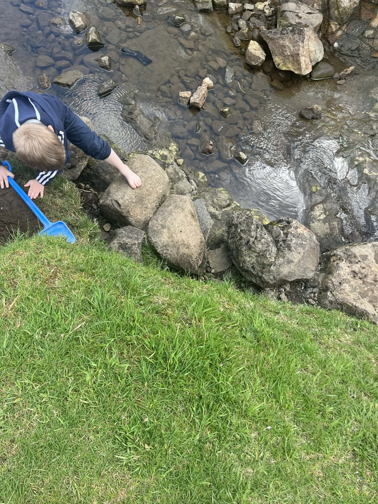 A boy playing along a small river